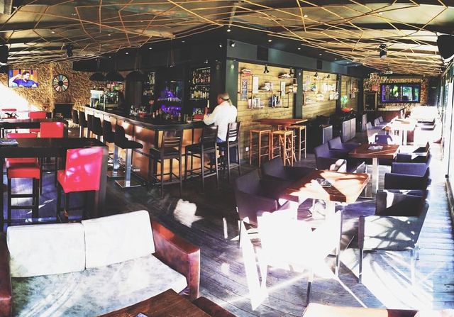 Το εσωτερικό του Cozy Cafe & Bar: το μπαρ, τα τραπέζια και οι πολυθρόνες